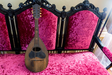 Old vintage mandoline on pink chair close