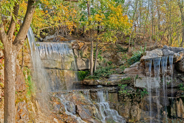 Fototapeta na wymiar Autumn landscape with waterfall and yellow trees, Sofievka park, Uman, Ukraine