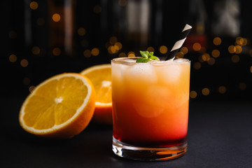 Fresh alcoholic Tequila Sunrise cocktail on grey table