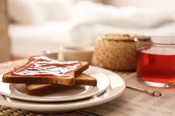 Toasts and tea on table indoors. Delicious morning meal
