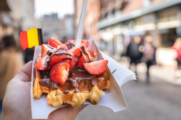 Traditional Belgian waffle dessert. Delicious cake with chocolate and fruits with flag. 