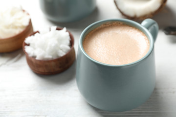 Delicious coffee with organic coconut oil on white wooden table
