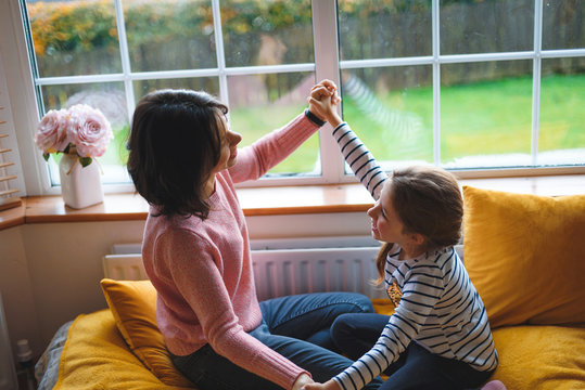 Mother And Daughter Playing On Bed