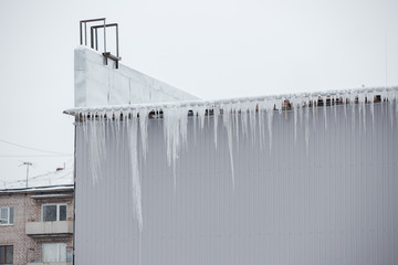 Very large icicles hang from the roof.