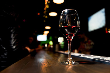 Glass of red wine on backlighted background