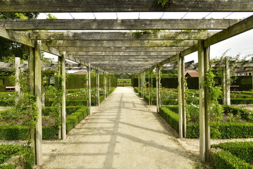 Allée sous pergola en bois aux jardins de la roseraie du domaine Coloma à Sint-Pieter-Leeuw 