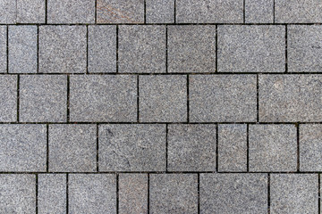 A sidewalk with grey brick stones in a nice pattern