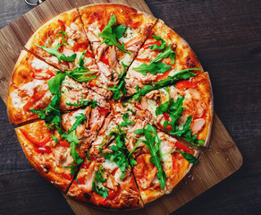 Pizza with Mozzarella cheese, salmon fish, tomato sauce, pepper. Italian pizza on wooden table background