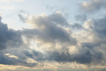 Amazing dark grey and white clouds during the sunset contrasted against a lighter color sky.