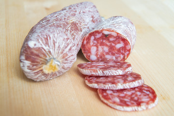 Salame tagliato, su tagliere di legno