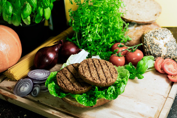 Bio-Brötchen mit Salat und vegetarischen Burger auf einem Holzbrett