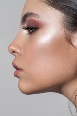 Profile photo of a beautiful girl with professional makeup, ideal skin, rose eyeshadows and nude lips. - obrazy, fototapety, plakaty