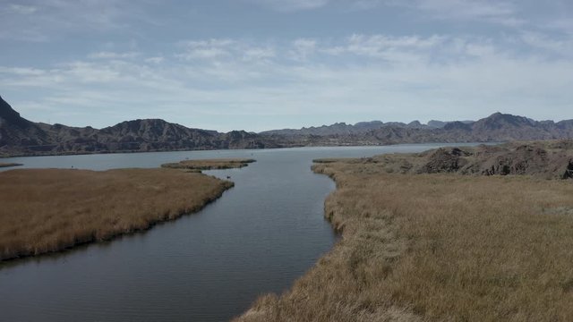 Aerial Drone View of Colorado river and Parker dam marsh and wetlands on a bright sunny day showing Arizona and California