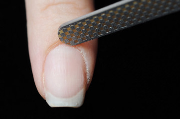 Close up photo of woman doing manicure with nail file