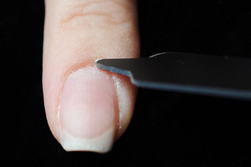 Close up photo of woman doing manicure with nail file