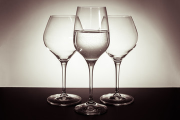 three glasses stand on the table in the center