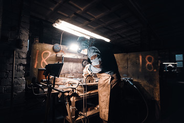 Busy man is working at his workplace at the metal factory.