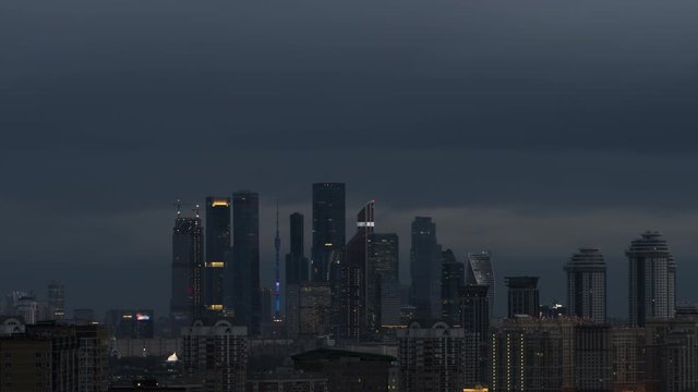 4K time lapse of early morning view to Moscow City business district. Fast dark clouds and soft sunrise beams on the skyscrapers