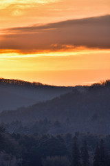 Cold Sunrise Over Tree Covered Hills And Frozen Water With Snow At Red House Lake, Allegany State Park, New York