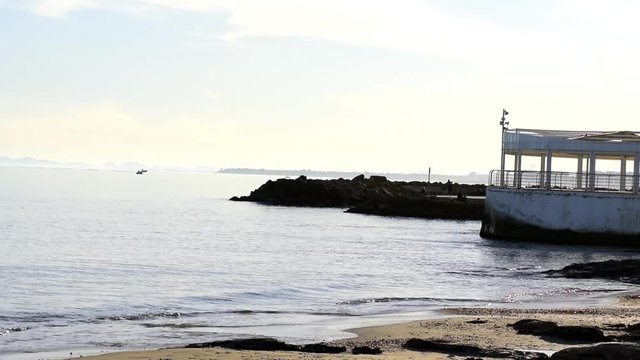 Scenic view of pier against seashore in Torrevieja, Alicante, Spain. El Tintero quisco over mediterranean Sea.