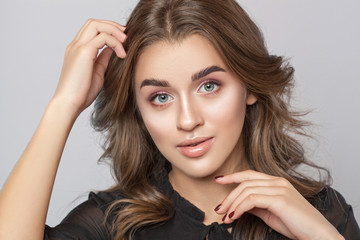 Fototapeta premium Portrait of a beautiful happy woman with long eyelashes, beautiful fresh nude make-up, thick eyebrows and with clean skin in a beauty salon. Eyelash extensions. Face close-up. Make-up concept