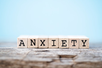 The word anxiety with a wood and light blue background - obrazy, fototapety, plakaty
