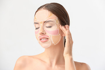 Woman with cosmetics on her face against white background