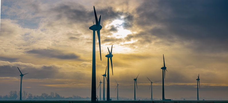Panoramaaufnahme eines Windparks im Sonnenaufgang