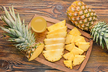 Fresh ripe pineapples and juice on wooden background