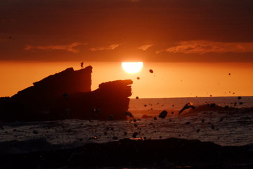 Obraz premium Silhouette of a person standing on a cliff at sunset at Playa Pelada in, Gunacaste Costa Rica