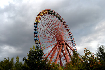 Buntes Riesenrad unter grauem Himmel in verlassenem Freizeitpark