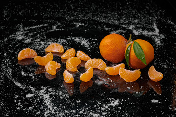 Fototapeta na wymiar Tangerines mandarines with water drops on black background. New Year 2020