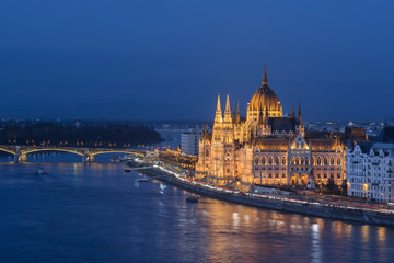 The Hungarian Parliament building illuminated at dusk on the Danube river bank