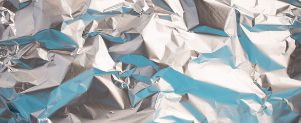 Background of Aluminium foil. Wallpaperof Metal crumpled foil. Reflect light.
