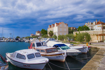 Fototapeta na wymiar Zlarin, Croatia / 18th May 2019: Boats and old stone houses in Zlarin island near Sibenik