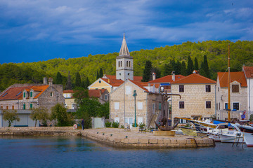 Fototapeta na wymiar Zlarin, Croatia / 18th May 2019: Seafront view on Zlarin, boats, harbour, Church of Holy Mary