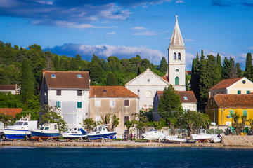 Naklejka na ściany i meble Zlarin, Croatia / 18th May 2019: Seafront view on Zlarin, boats, harbour, Church of Holy Mary