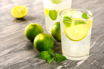 Lemonade mojito cocktail with fresh lemon and mint on grey background .Healthy citrus summer.