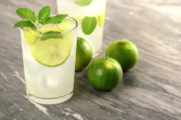 lemonade cocktail with freh lemon and mint on grey background.healthy summer drink