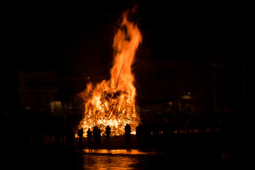 Silhouette of people watching a big bonfire