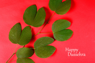 Indian Festival Dussehra, showing golden leaf on red background. Greeting card.