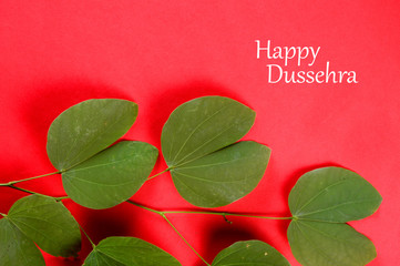 Indian Festival Dussehra, showing golden leaf on red background. Greeting card.