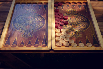 Backgammon board game for two players on a special board. Sun rays