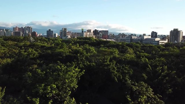 Green Oasis in Urban Jungle, Daan Forest Park in Taipei, Taiwan, Ascending Aerial View of Neighborhood on Golden Hour Sunlight