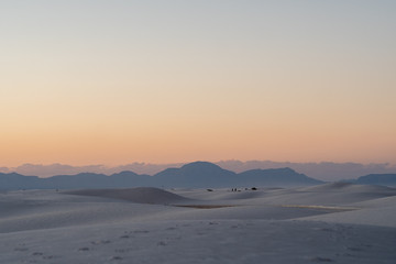 Desert scene at sunset with mountains in distance