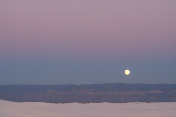 Moonrise in the desert with mountains in distance