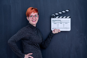 redhead woman holding movie clapper