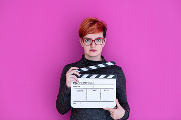 woman holding movie clapper isolated on pink background