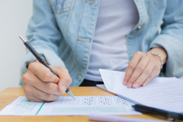 high school,university student study.hands holding pencil writing paper answer sheet.sitting lecture chair taking final exam attending in examination classroom.concept scholarship for education abroad