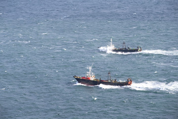 Fishing boats sailing for new hunting on the sea. Trawler fishing boat sailing in open waters. along the coast of Taejongdae recreational park.